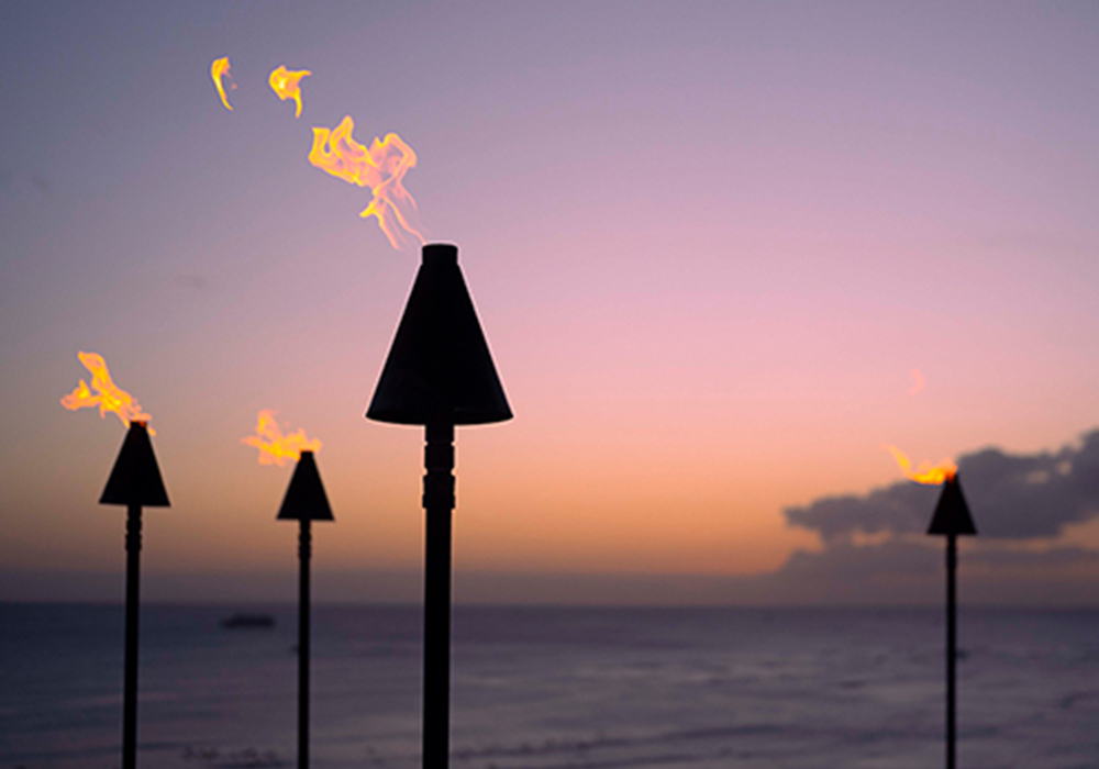 Torches with a sunset behind it