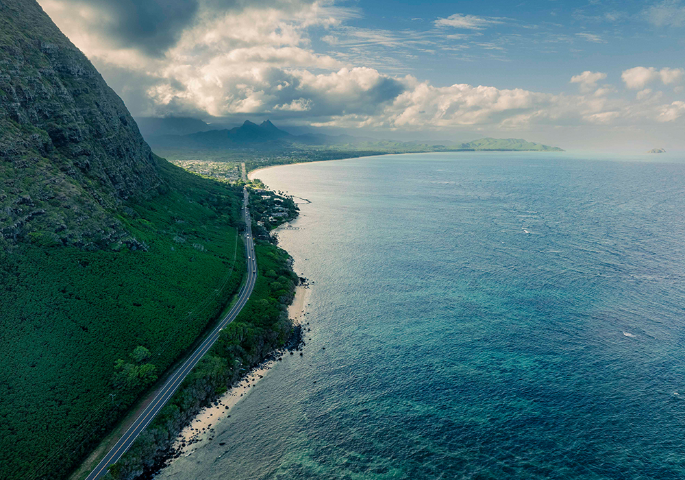 A sky shot of a road next to the ocean