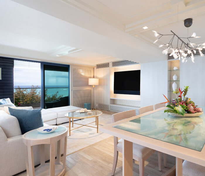 Living room with a TV, couch, balcony, and dining area.