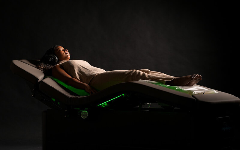 Woman in treatment chair and sound headphones.